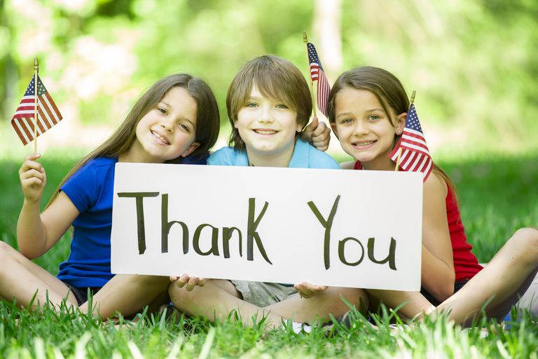 children-hold-thank-you-sign-with-american-flags-memorial-day-471031754-587a79fd3df78c17b6a07d49